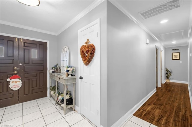 foyer entrance featuring light tile patterned floors, baseboards, visible vents, and ornamental molding