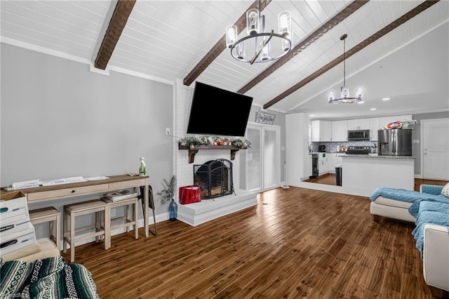 living room with dark wood-style flooring, lofted ceiling with beams, an inviting chandelier, a brick fireplace, and baseboards