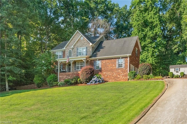 view of front of home featuring stone siding, a front lawn, and brick siding