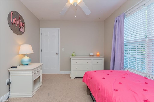 bedroom with light carpet, baseboards, and a ceiling fan