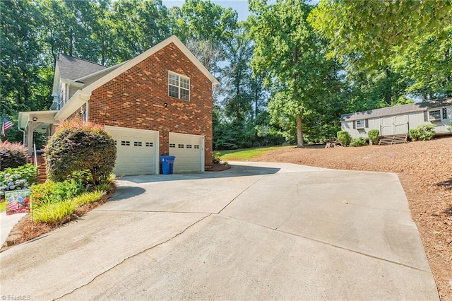 view of home's exterior featuring concrete driveway, brick siding, and an attached garage