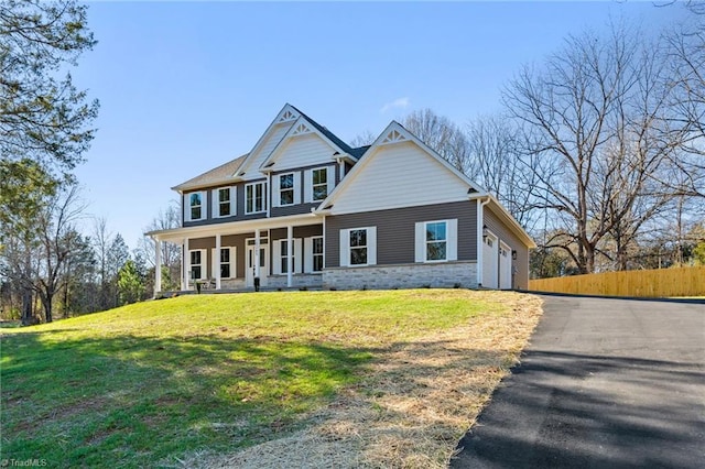 craftsman house featuring covered porch, a front yard, and a garage