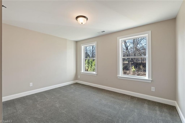 spare room featuring dark carpet