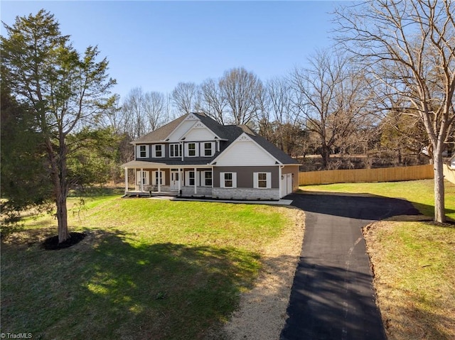 view of front of home with covered porch, a front lawn, and a garage