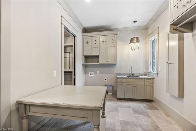 kitchen featuring cream cabinets, sink, and pendant lighting