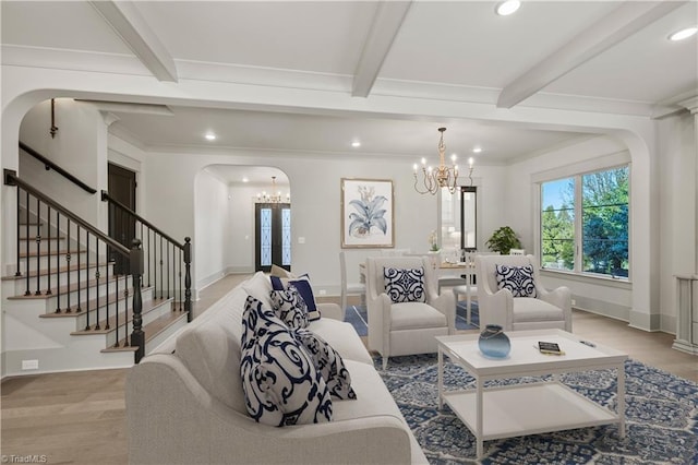 living room with an inviting chandelier, light wood-type flooring, and beamed ceiling