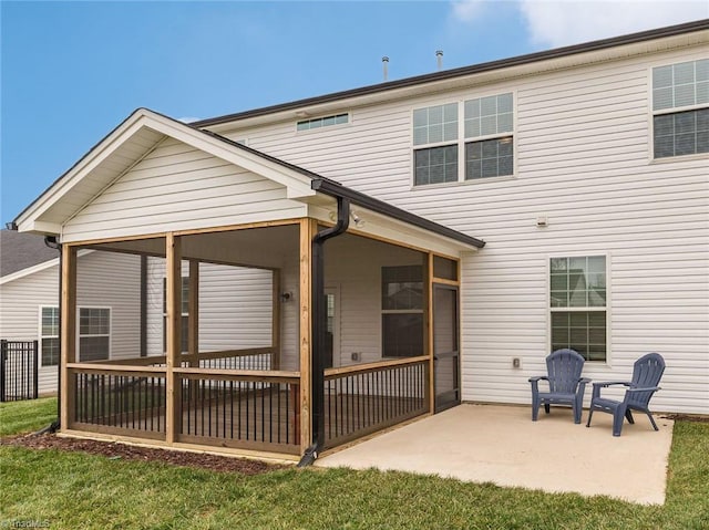 rear view of house with a yard, a patio, and a sunroom