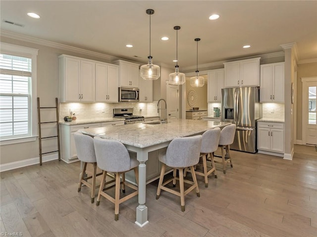 kitchen featuring visible vents, crown molding, light wood-style flooring, appliances with stainless steel finishes, and white cabinets