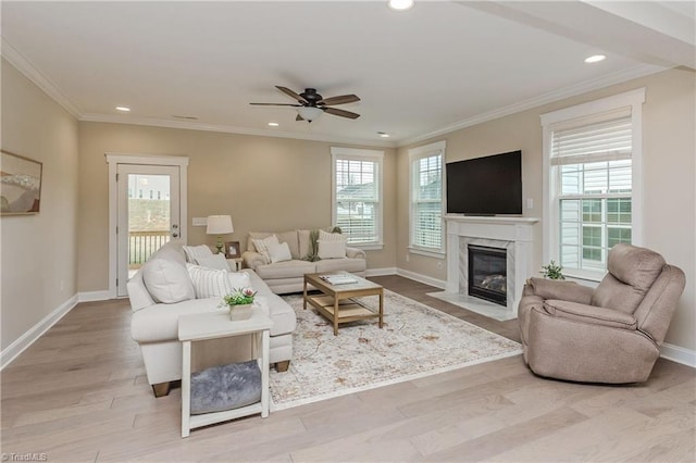 living room featuring wood finished floors, baseboards, a wealth of natural light, and ceiling fan