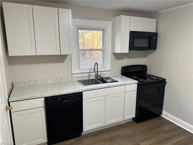 kitchen with dark wood finished floors, white cabinets, a sink, and black appliances