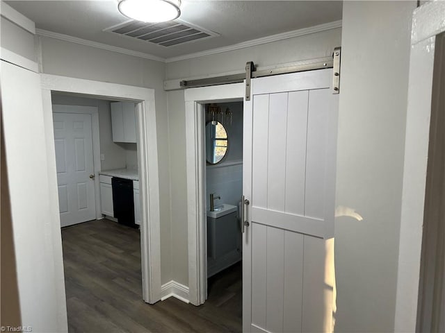 corridor featuring dark wood-style floors, a barn door, visible vents, and crown molding