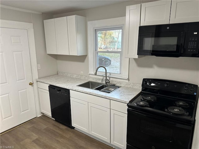 kitchen featuring dark wood-type flooring, white cabinetry, a sink, and black appliances