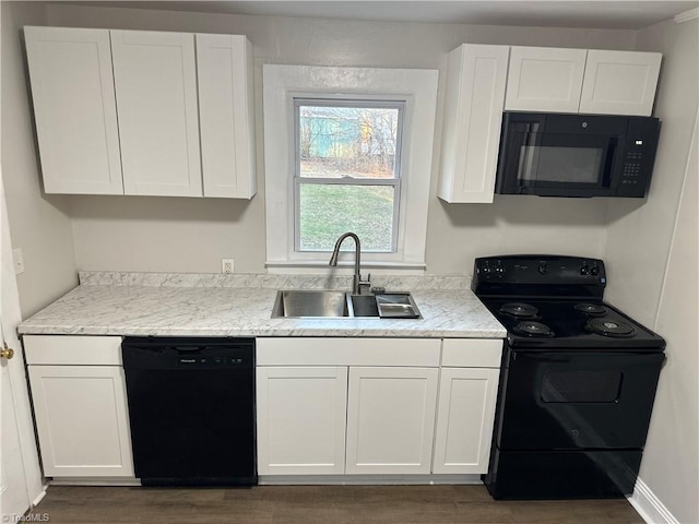 kitchen featuring a sink, white cabinets, light stone countertops, black appliances, and dark wood finished floors