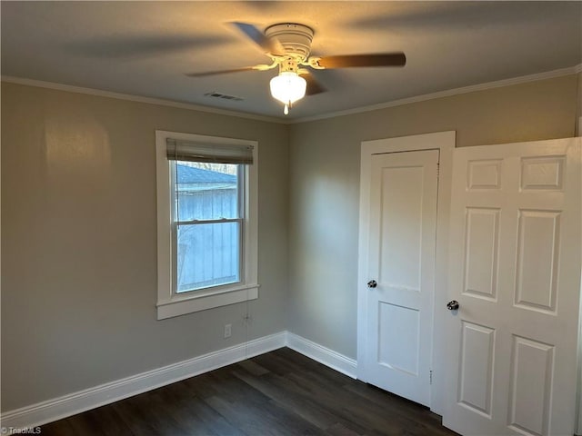 unfurnished bedroom with baseboards, visible vents, dark wood-type flooring, and ornamental molding