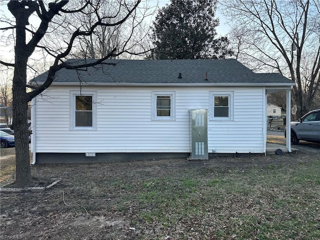 rear view of property with a shingled roof