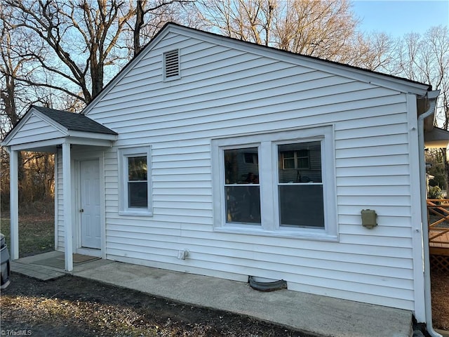 back of house with roof with shingles