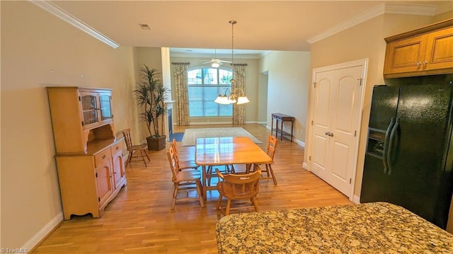 dining area featuring ceiling fan with notable chandelier, light hardwood / wood-style floors, and crown molding