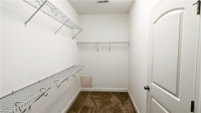 spacious closet featuring dark carpet