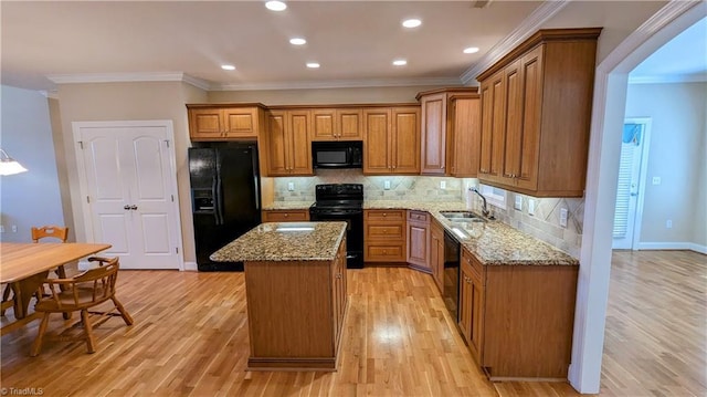 kitchen featuring tasteful backsplash, ornamental molding, sink, black appliances, and a kitchen island