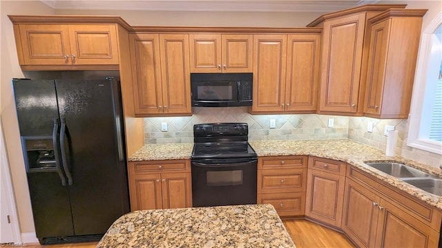 kitchen featuring decorative backsplash, black appliances, and light stone counters