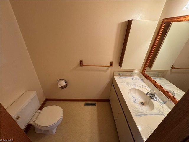 bathroom featuring toilet, baseboards, visible vents, and vanity