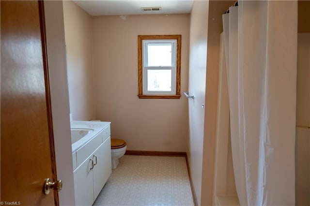 bathroom featuring baseboards, visible vents, toilet, tile patterned floors, and vanity