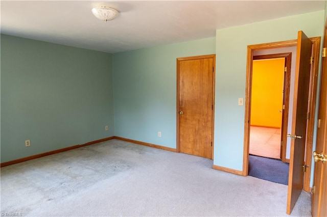 carpeted empty room featuring baseboards