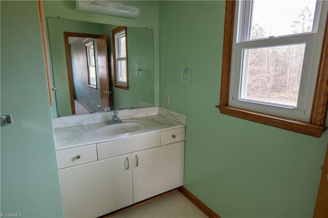 bathroom with baseboards, a wealth of natural light, and vanity