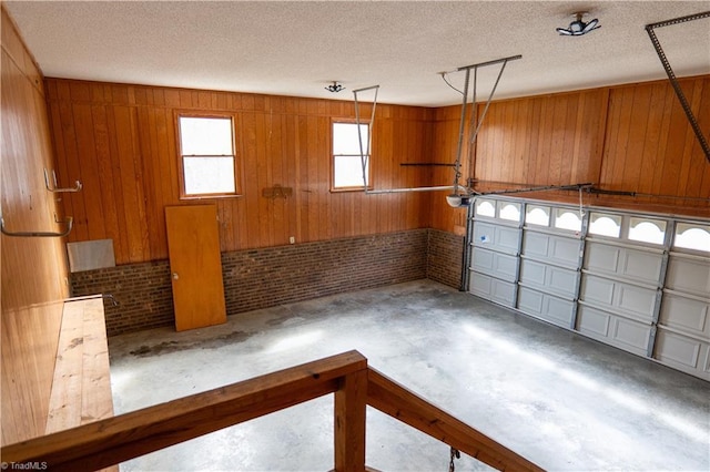 garage with a garage door opener and wood walls