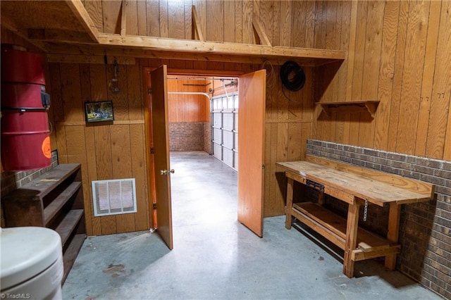 bathroom featuring concrete floors, visible vents, and wooden walls