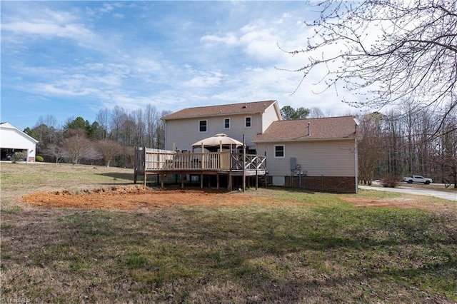 rear view of house with a yard and a wooden deck