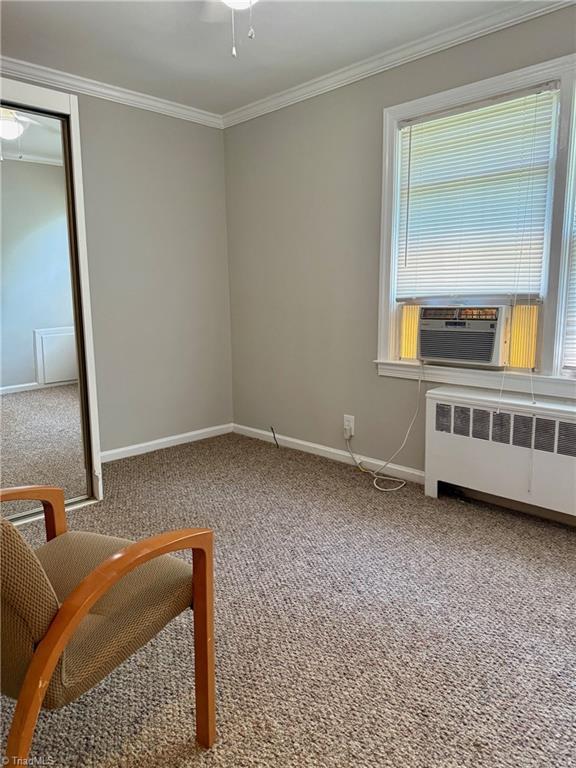 1500 Brent Ct Unit 9-B, Burlington, NC 27215 - sitting room featuring radiator heating unit, carpet flooring, baseboards, crown molding, and cooling unit