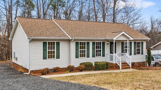 single story home with crawl space, a shingled roof, and a front yard