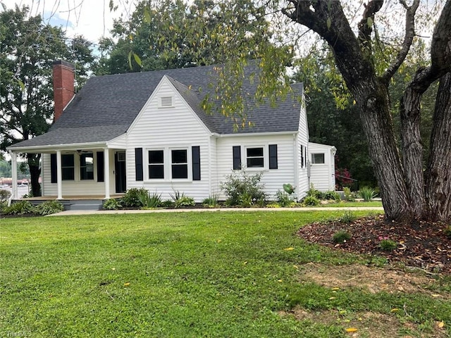 new england style home with covered porch and a front yard