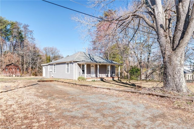 view of front facade featuring a shed, a porch, and an outbuilding