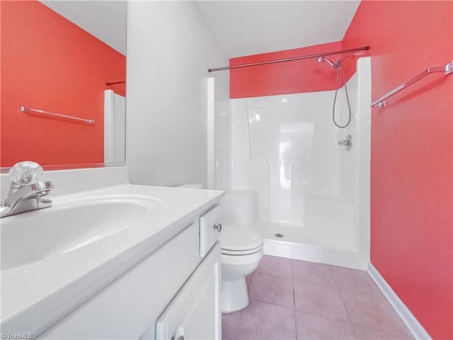 bathroom featuring vanity, baseboards, walk in shower, tile patterned floors, and toilet