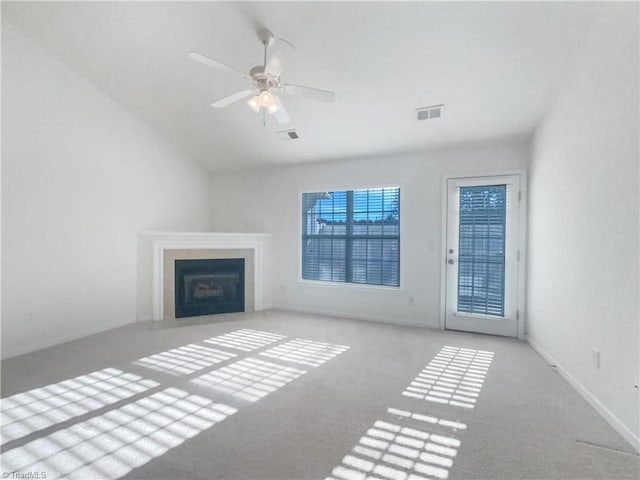 unfurnished living room featuring visible vents, a fireplace with flush hearth, ceiling fan, vaulted ceiling, and carpet flooring