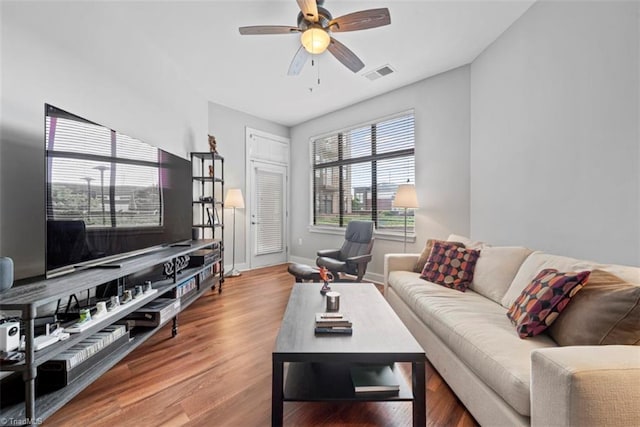 living room featuring wood-type flooring and ceiling fan