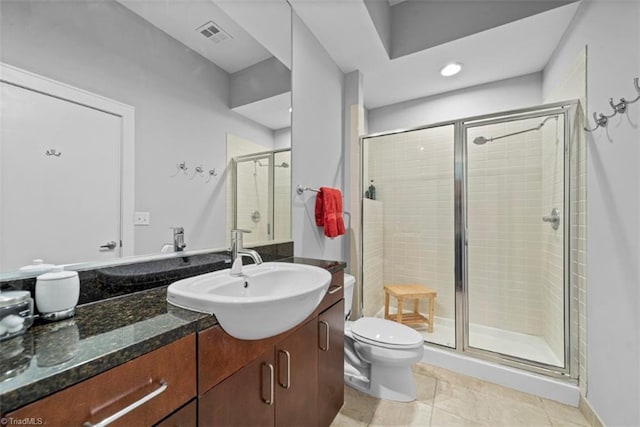 bathroom with vanity, toilet, tile patterned floors, and a shower with shower door