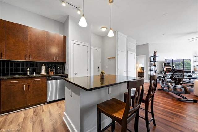 kitchen featuring a center island, hardwood / wood-style floors, sink, a breakfast bar area, and stainless steel dishwasher