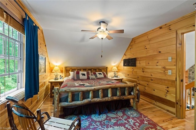 201 Cherokee Cir, Jefferson, NC 28640 - bedroom featuring wooden walls, multiple windows, vaulted ceiling, light wood finished floors, and a ceiling fan