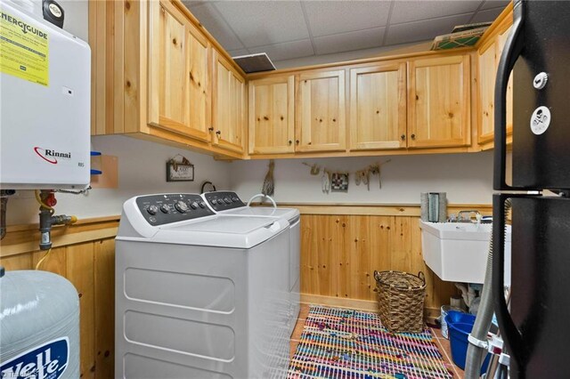 201 Cherokee Cir, Jefferson, NC 28640 - laundry room with tankless water heater, washer and dryer, wainscoting, cabinet space, and wood walls