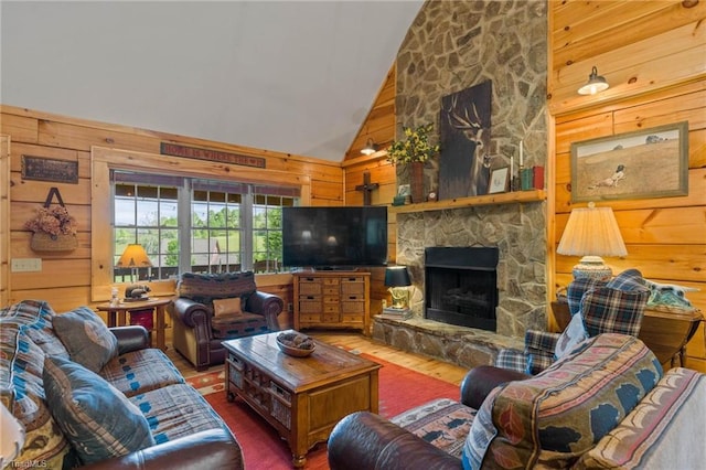 201 Cherokee Cir, Jefferson, NC 28640 - living room featuring hardwood / wood-style flooring, wood walls, a stone fireplace, and high vaulted ceiling