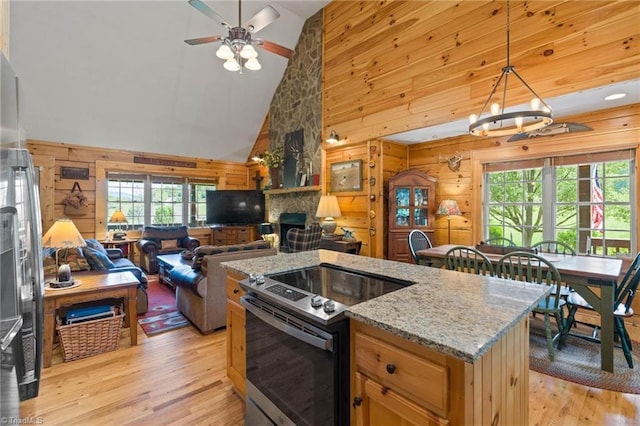201 Cherokee Cir, Jefferson, NC 28640 - kitchen with electric stove, wooden walls, open floor plan, light wood-style floors, and high vaulted ceiling