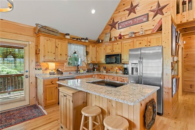 201 Cherokee Cir, Jefferson, NC 28640 - kitchen featuring black appliances, plenty of natural light, light wood-style floors, a kitchen island, and wooden walls