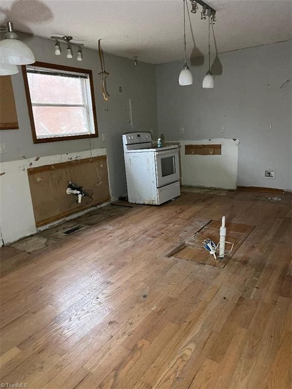 kitchen with white range with electric cooktop, hardwood / wood-style floors, and hanging light fixtures