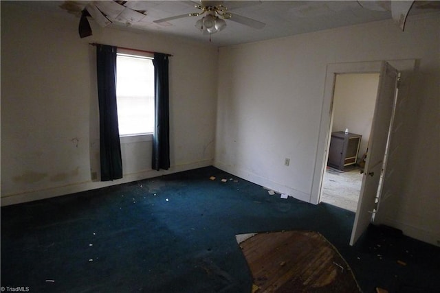 empty room with dark carpet and ceiling fan