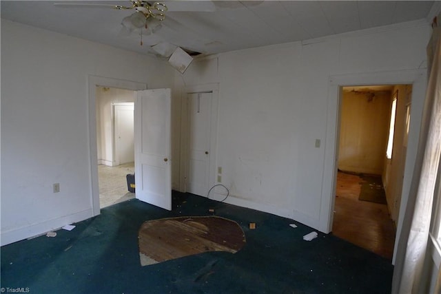 empty room featuring ceiling fan and dark tile floors