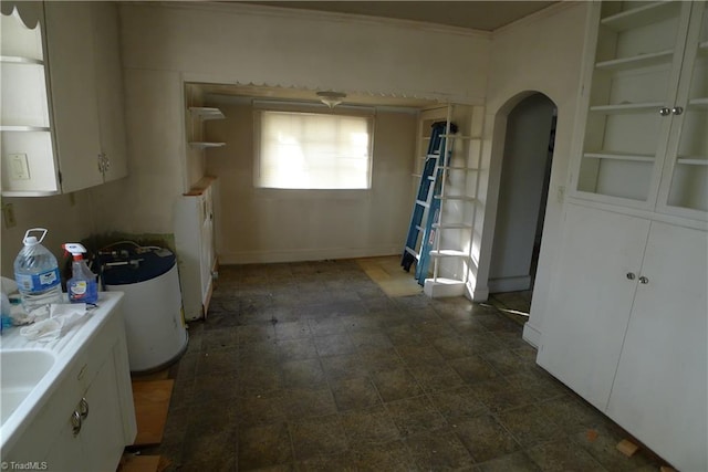 kitchen featuring white cabinets, dark tile flooring, and built in shelves