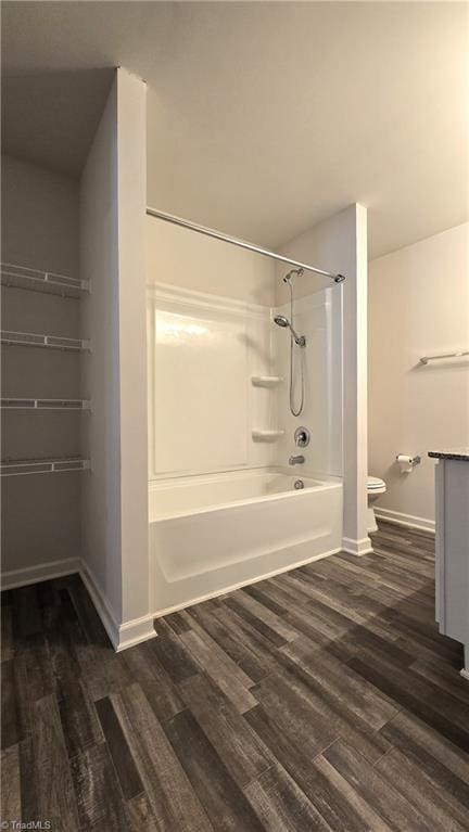 bathroom with toilet, shower / bath combination, and wood-type flooring